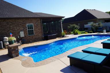 Backyard swimming pool with patio furniture and house