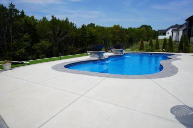 Backyard inground pool with surrounding patio area