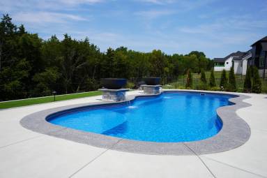 Inground swimming pool with blue water in backyard