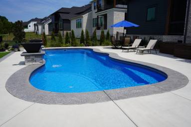 Backyard inground pool with patio and lounge chairs
