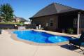 Backyard swimming pool beside modern house design