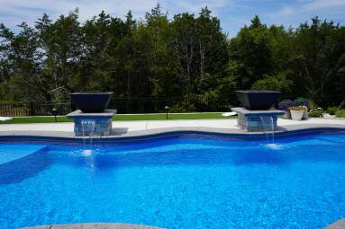 Backyard swimming pool with blue water and fountains