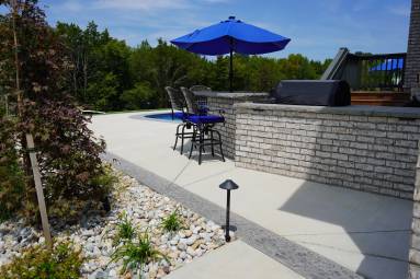 Backyard patio with pool and blue umbrella