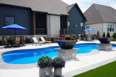 Backyard pool patio with furniture and umbrellas
