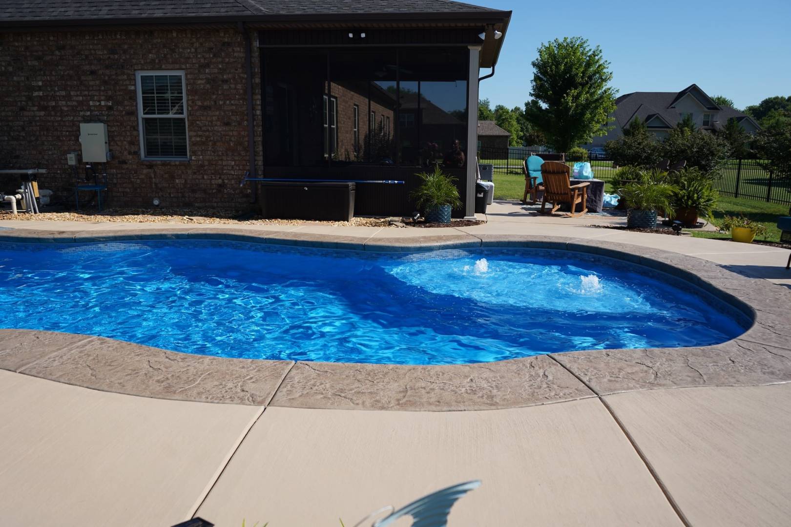 Backyard inground swimming pool on sunny day