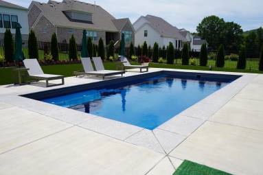 Backyard swimming pool with lounge chairs and houses